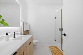 A bathroom with a white sink and a toilet.