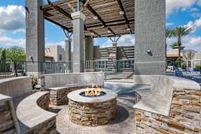A patio with a fire pit and seating area.