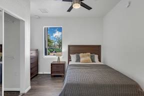 A bedroom with a bed, nightstand, and window.
