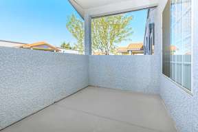A balcony with a white wall and a grey floor.