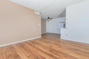 A room with wooden flooring and white walls.