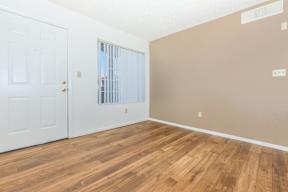 A room with a white door and a window with blinds.