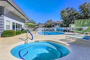 A swimming pool with a slide and a building in the background.