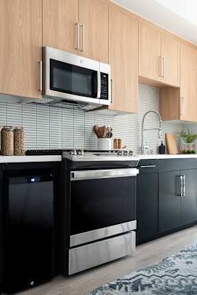 A modern kitchen with a black oven and a microwave above it.