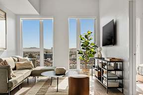 A living room with a couch, a chair, a coffee table, and a television.