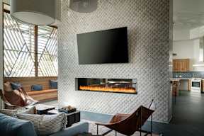 A modern living room with a fireplace and a flat screen TV mounted on the wall.