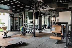 A gym with a variety of equipment including weights and cardio machines.