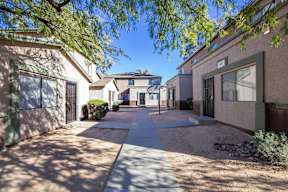 A sunny day in a residential area with houses and a sidewalk.