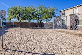 A sandy area with a fence and a sign that says "Pet Mutt".