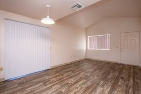 A room with wooden flooring and a white door.