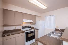 A kitchen with a stove, oven, and sink.