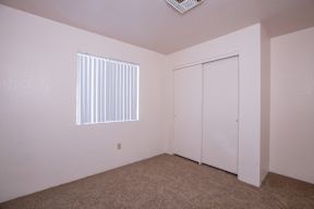 A room with a window and a closet.