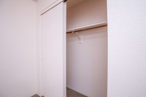 A white door is open to a white room.
