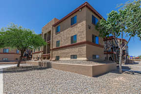 A multi-story building with a flat roof and a balcony on the second floor.