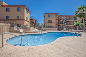 A swimming pool in front of apartment buildings.