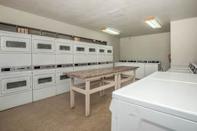 A row of white ovens are lined up in a room.
