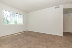 Empty room with carpeted floor and a window.