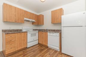 A kitchen with wooden cabinets and white appliances.