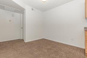 A room with a carpeted floor and a door on the left.