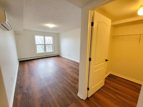 an empty living room with wood flooring and a white door
