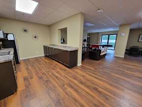 a kitchen and living room with wood flooring in an office