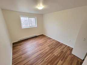 a living room with wood flooring and a window