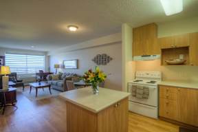 A kitchen with a white stove and wooden cabinets.