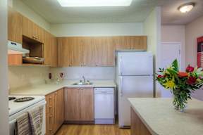 A kitchen with a white fridge, dishwasher and stove.