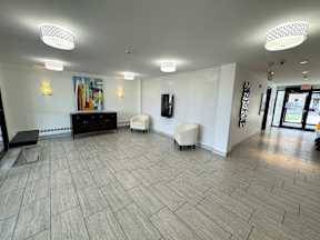 A spacious room with a wooden floor and white walls.