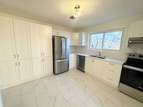 A kitchen with white cabinets and appliances.