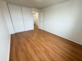 A room with wooden flooring and white walls.