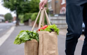 a man carrying a bag full of vegetables