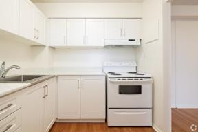 A white kitchen with a stove and cabinets.