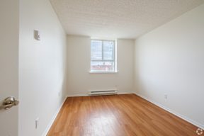 A room with a window and wooden floors.