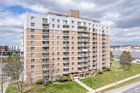 A large apartment building with a grassy area in front.