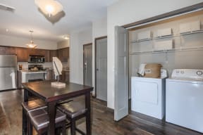 a kitchen with a washer and dryer and a dining table at InterUrban Apartments, Montana, 59106