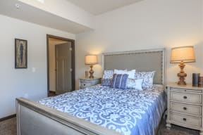 a bedroom with a large bed and two night stands with lamps at InterUrban Apartments, Billings Montana