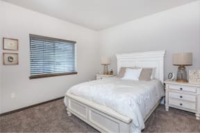 a bedroom with a bed and two nightstands at InterUrban Apartments, Billings, 59106