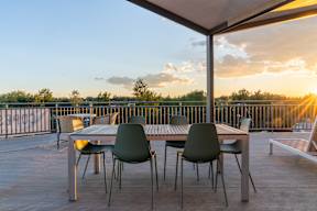 A table with chairs is set up on a wooden deck.at Copestone Apartments, Idaho
