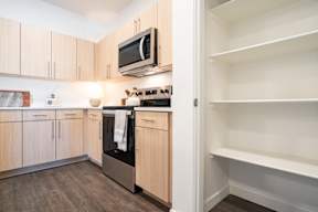 A kitchen with wooden cabinets and a microwave above the stove.at Copestone Apartments, Idaho
