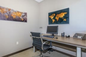 a desk with a computer and a map of the world on the wall at InterUrban Apartments, Billings Montana