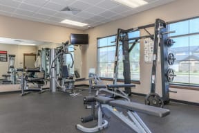 a fitness room with exercise equipment and a flat screen tv at InterUrban Apartments, Billings, MT