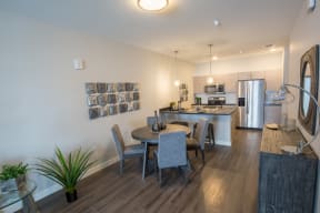 a dining area with a table and chairs and a kitchen in the background at Shiloh Commons, Billings, MT