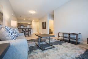 a living room with a couch coffee table and a kitchen in the background at Shiloh Commons, Billings, MT