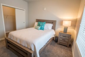 a bedroom with a bed and a nightstand with a lamp at Shiloh Commons, Billings, MT 59102