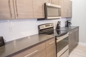 a kitchen with wooden cabinets and stainless steel appliances at Shiloh Commons, Billings