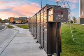 a row of mailboxes in front of a building with a sunset in the background at Shiloh Commons, Billings, 59102