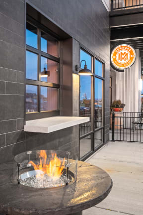 a fire pit in front of a window with a sign on the side of the building at Shiloh Commons, Montana
