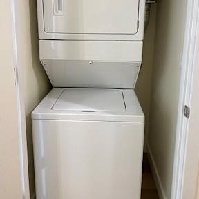 A white washing machine in a small room.