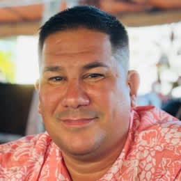 A man wearing a red shirt with a floral pattern.